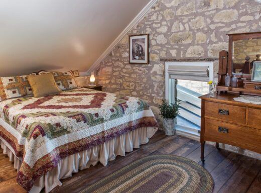 The Behr Barn bedroom with stone walls at Behr House